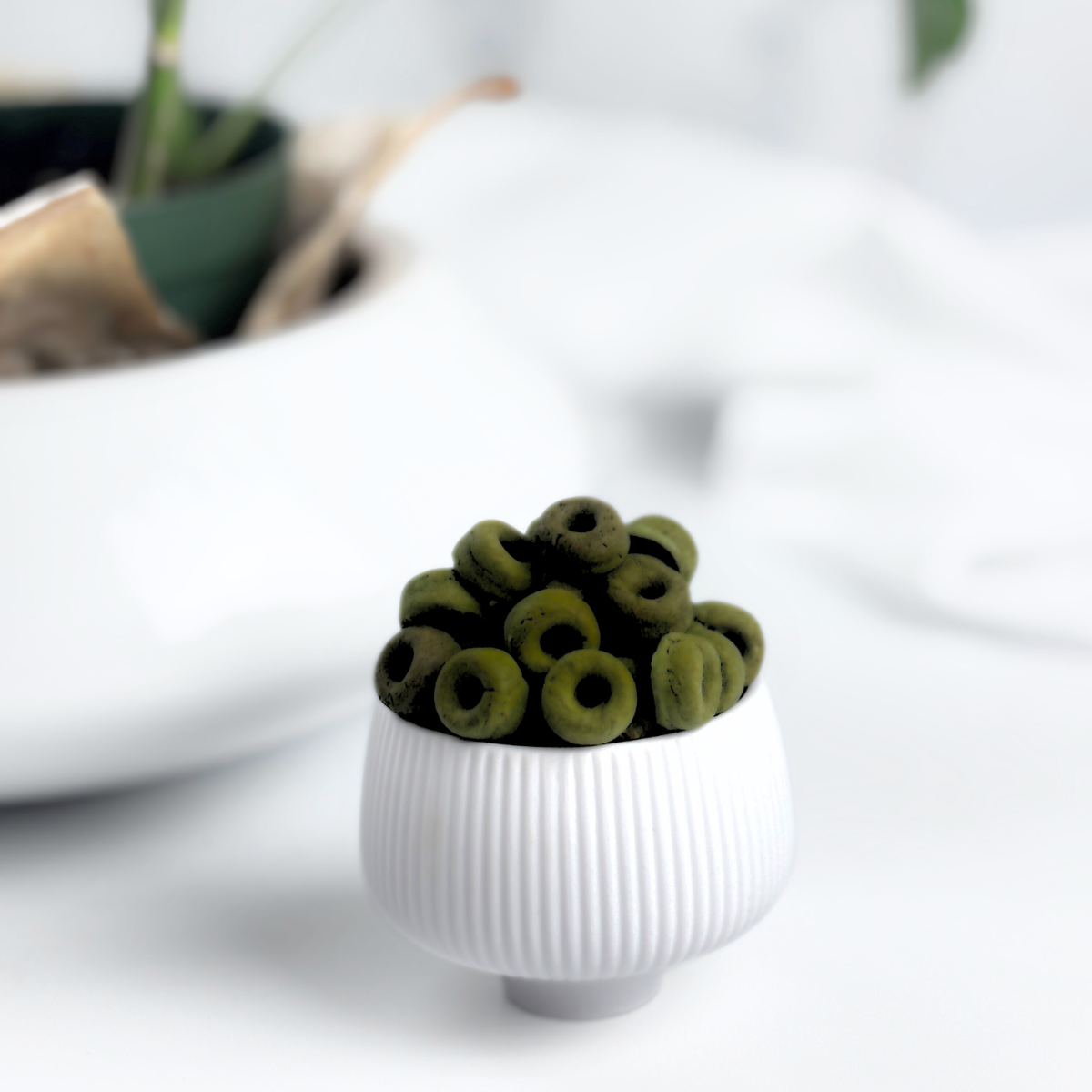 Superfood Spinach, Green Spirulina and Cottage Cheese Healthy Dog Treats in the shape of mini donuts. We call them Daisy Loops a playful color reference to Fruit Loops but for dogs.